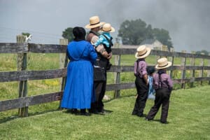 Ohio's Amish Country featuring an Amish family observing countryside together.