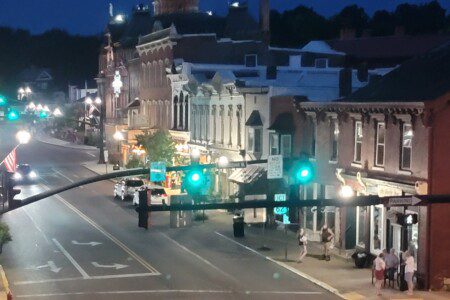 Historic downtown Millersburg glowing at dusk with traffic lights and evening sky