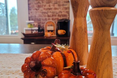 Glossy rust-toned decorative pumpkin as a fall centerpiece on a table