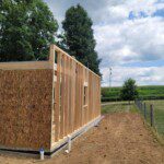 Framed exterior wall of Psithurism House with cornfields beyond, Holmes County, Ohio