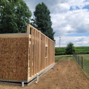 Framed exterior wall of Psithurism House with cornfields beyond, Holmes County, Ohio