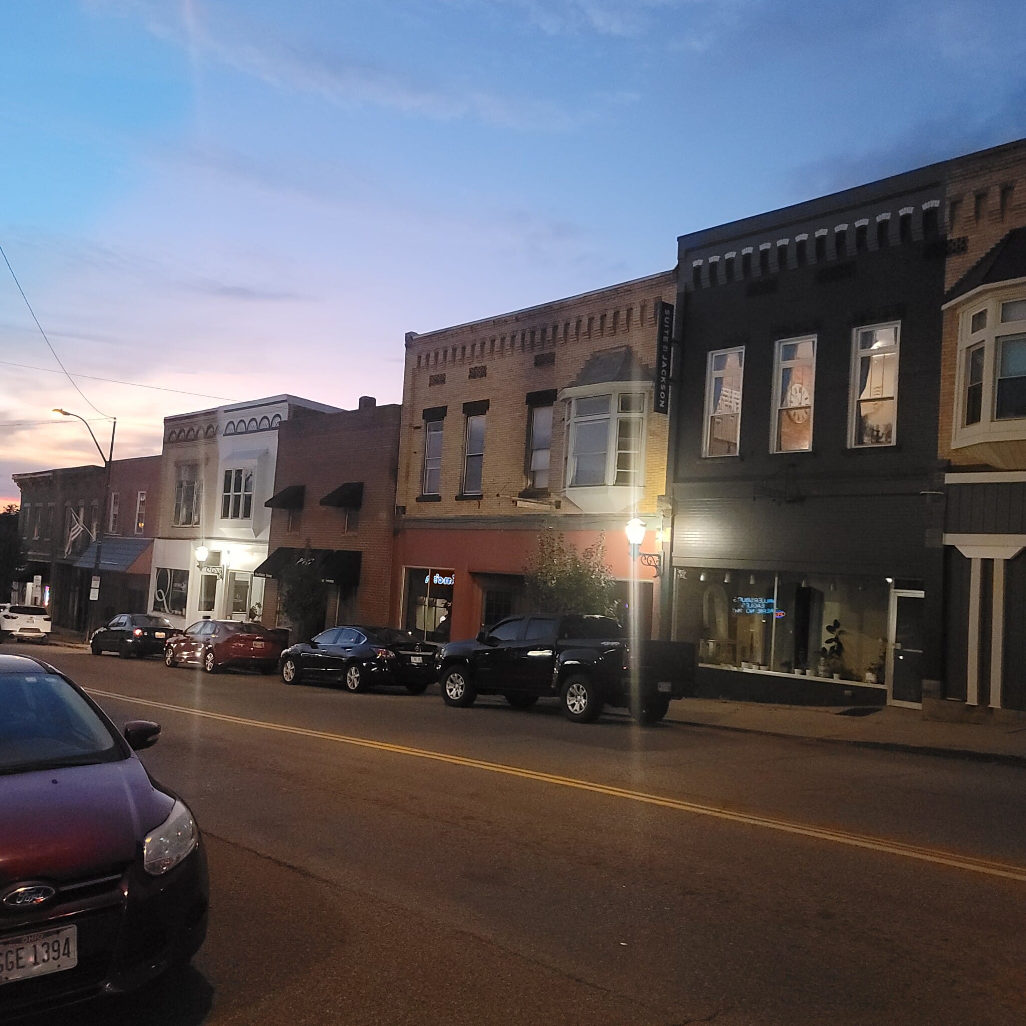 Suite on Jackson storefront on Millersburg's downtown square glowing at sunset