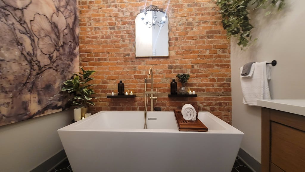Soaking tub with brick wall backdrop and candles for a perfect end to shopping in Ohio's Amish country.