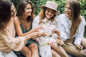 Group of women celebrating a girls' trip to Holmes County, Ohio with a rosé toast in a garden